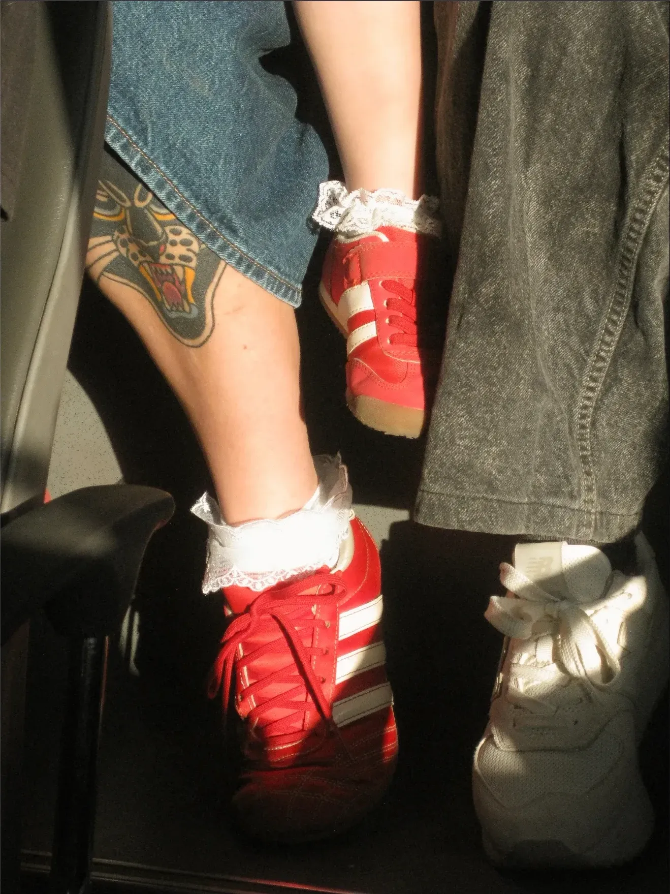 Pies con zapatillas rojas y calcetines con vuelos, de cerca